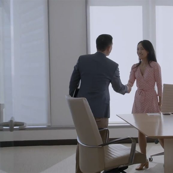 Man and woman shaking hands in conference room